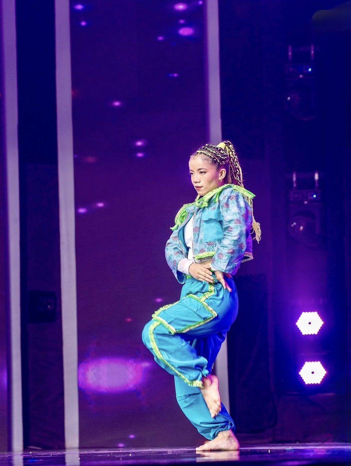 Amrita Rai performing a hip hop routine in a teal streetwear costume