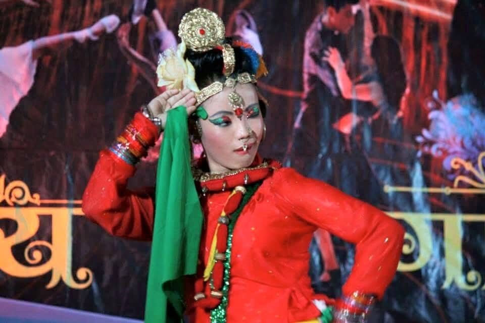 Amrita Rai in traditional red costume and headdress for a Nepali folk performance